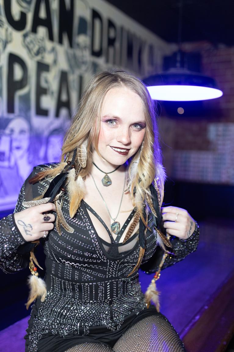 Ariel Jade smiling under purple bar light